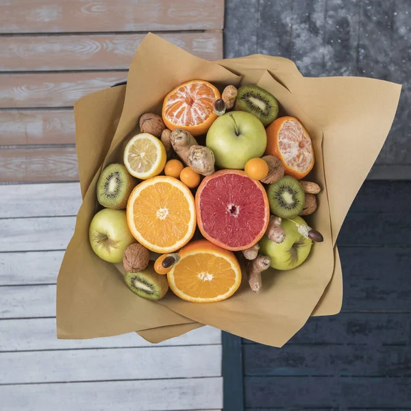 Bovenaanzicht van vruchten en noten boeket verpakt in kraftpapier — Stockfoto