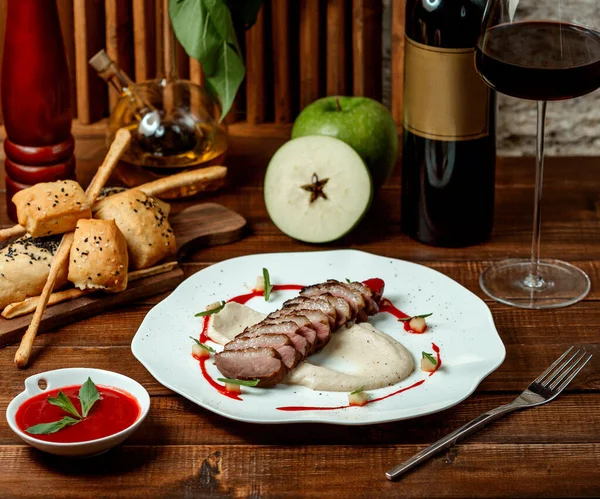 Trozos de carne de res servidos en la parte superior de puré de papa adornado con salsa — Foto de Stock