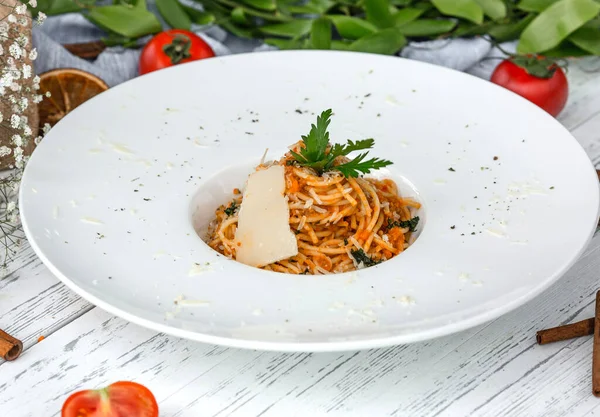 Кремовые морковные спагетти с помидорами, украшенные петрушкой и пармезаном — стоковое фото