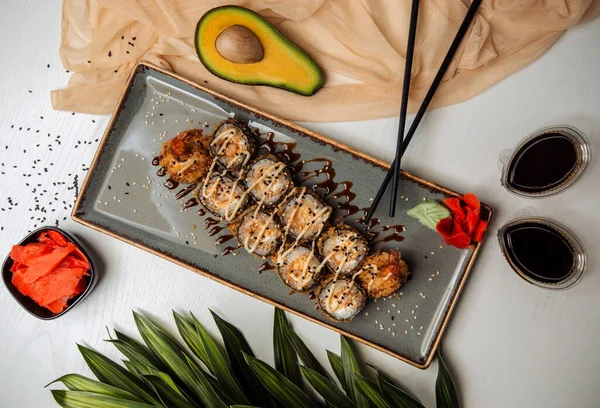 Susamlı kızarmış suşi ruloları, teryaki sosu, wasabi ve zencefil ile servis edilir.