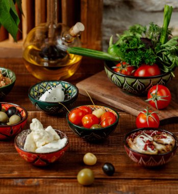 Turşu, peynir ve zeytin dolu küçük kaplarda yan yemekler.