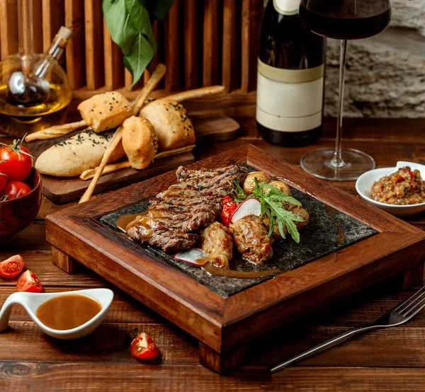 Marinated lamb steak and lula kebab served with baby potatoes and grilled tomato — Stock Photo, Image