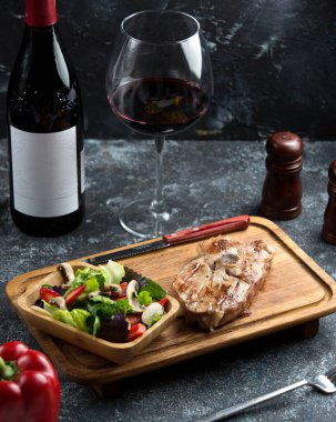 Mantar, çilek, dolma biber, marul salatası ile servis edilen hafif ızgara kuzu bifteği.