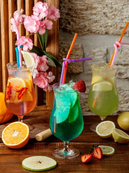 Tři sklenice ovocných koktejlů s jahodou, pomerančem, jablkem a limetkou — Stock fotografie