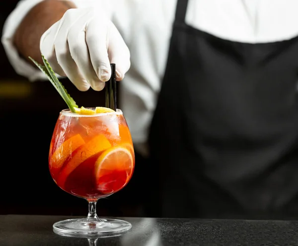 Waiter puts plastic straws in sangria cocktail in glass — Stock Photo, Image