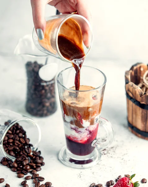 Kvinna hälla kaffe skjuten i jordgubbssirap mix med glass — Stockfoto