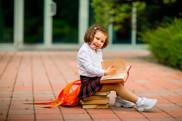 Mała Dziewczynka Szkolnym Mundurku Okularach Siedząca Stercie Książek Pobliżu Szkoły — Zdjęcie stockowe