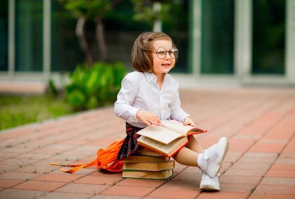 Una Bambina Uniforme Scolastica Occhiali Seduta Una Pila Libri Vicino — Foto Stock