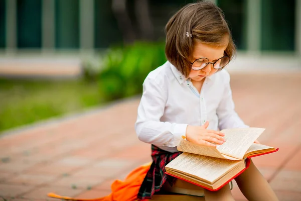 Ένα Μικρό Κορίτσι Σχολική Στολή Και Γυαλιά Κάθεται Μια Στοίβα — Φωτογραφία Αρχείου