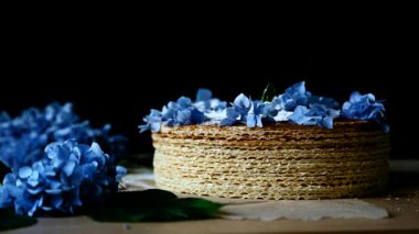 Beyaz pudra şekeri mavi çiçeklerle süslenmiş waffle kekinin üzerine serpilmiştir.
