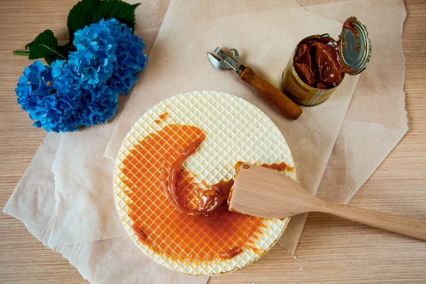 Step by step, making a waffle cake, with condensed milk, and decorating with blue flowers — Stock Photo, Image