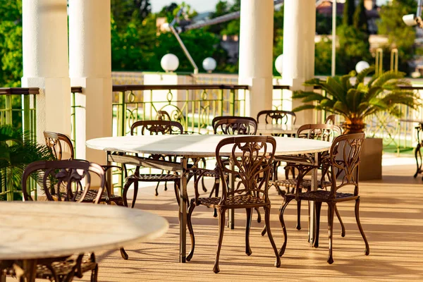 outdoor summer terrace, with stylish furniture, in a cafe at sunset