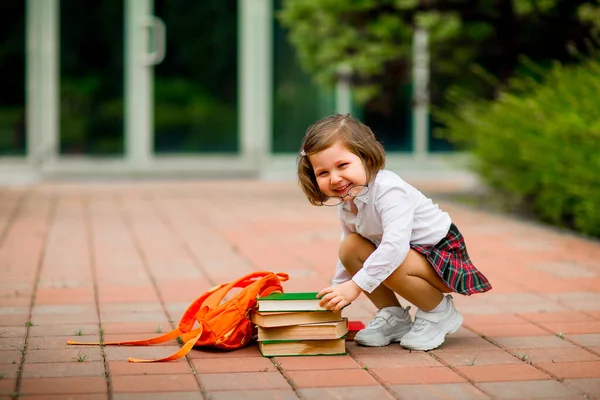 Kleines Mädchen in Schuluniform und Brille, mit Schulbüchern — Stockfoto