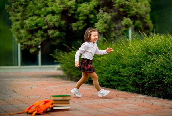 Kleines Mädchen in Schuluniform und Brille, mit Schulbüchern — Stockfoto