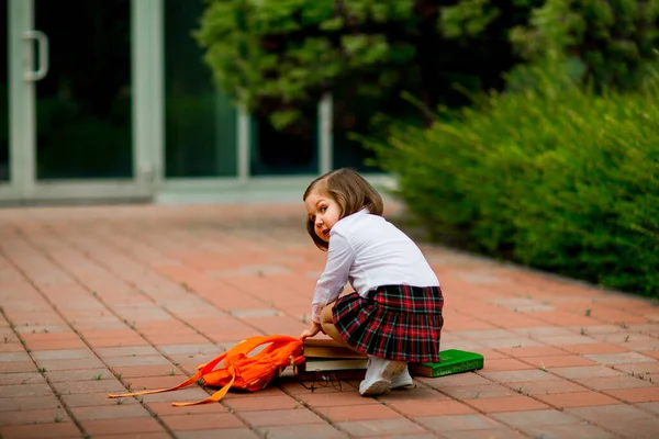 Bambina in uniforme scolastica e occhiali, con libri di testo — Foto Stock