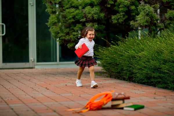 Bambina in uniforme scolastica e occhiali, con libri di testo — Foto Stock
