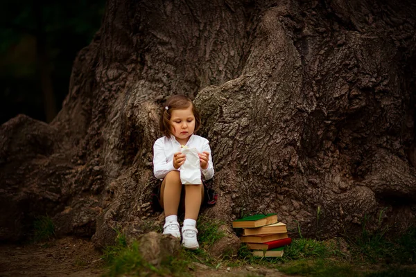 Een Meisje Schooluniform Eet Een Broodje Bij Een Grote Boom — Stockfoto