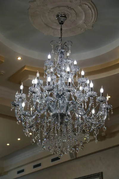 Tavanda Swarovski kristallerinden yapılmış parlak bir avize asılı.