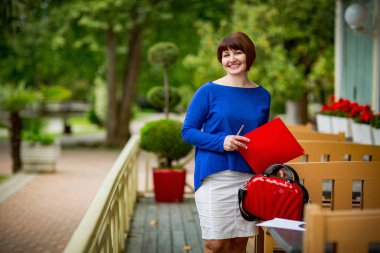 Muhasebeci olarak çalışan mavi ceketli bir kadının iş portresi. Belgeleri ve hesap makinesi olan bir ekonomist.