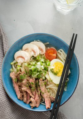 Asya ramen çorba, et, yumurta, frenk soğanı, kase mantar. Üstten görünüm.