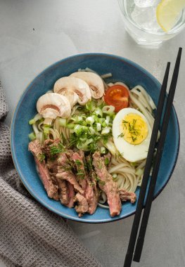 Asya ramen çorba, et, yumurta, frenk soğanı, kase mantar. Üstten görünüm.
