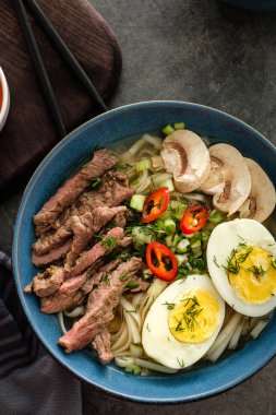 Asya ramen çorba, et, yumurta, frenk soğanı, kase mantar. Üstten görünüm.