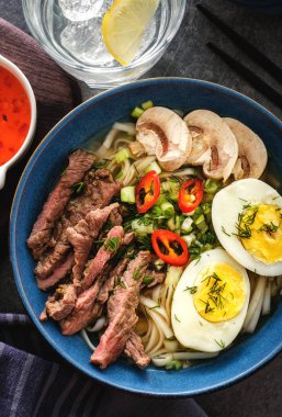 Asya ramen çorba, et, yumurta, frenk soğanı, kase mantar. Üstten görünüm.