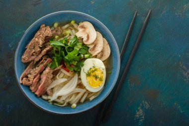 Asya ramen çorba, et, yumurta, frenk soğanı, kase mantar. Üstten görünüm.