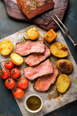 Üzerinde kesme tahtası ızgara sebzeli biftek dilimlenmiş. Yukarıdan görüntülemek.