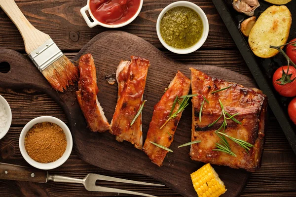 Lezzetli Mangalda kaburga baharatlı bir kötek sosu ile terbiyeli ve eski bir rustik ahşap doğrama tahtası üzerinde kıyılmış taze sebze ile servis.