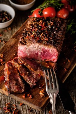 Üzerinde kesme tahtası ızgara sebzeli biftek dilimlenmiş 