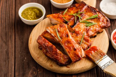 Lezzetli Mangalda kaburga baharatlı bir kötek sosu ile terbiyeli ve eski bir rustik ahşap doğrama tahtası üzerinde kıyılmış taze sebze ile servis