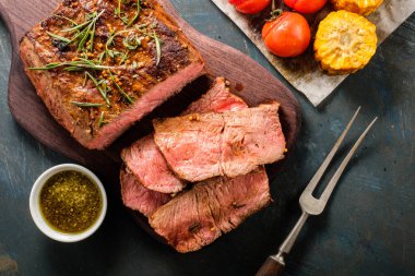 Üzerinde kesme tahtası ızgara sebzeli biftek dilimlenmiş 