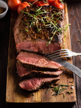 Üzerinde kesme tahtası ızgara sebzeli biftek dilimlenmiş 