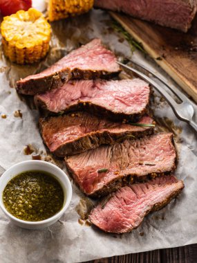 Sığır eti ızgara sebzeli ahşap masa üzerinde beyaz kağıt üzerine dilimlenmiş. Üstten görünüm.