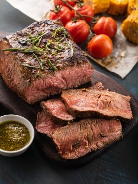 Üzerinde kesme tahtası ızgara sebzeli biftek dilimlenmiş 