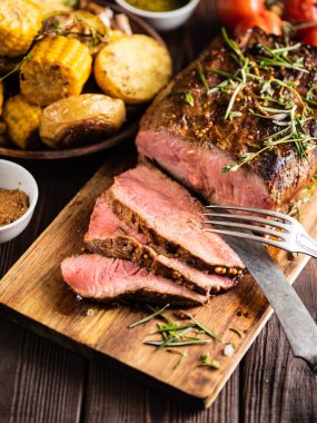 Üzerinde kesme tahtası ızgara sebzeli biftek dilimlenmiş 