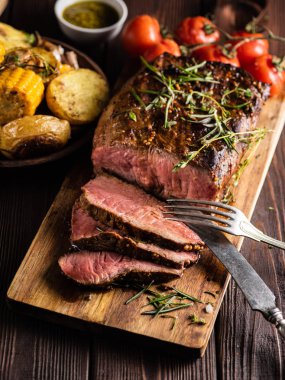 Üzerinde kesme tahtası ızgara sebzeli biftek dilimlenmiş 