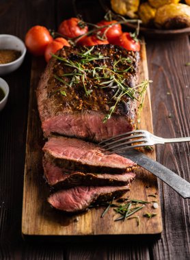 Üzerinde kesme tahtası ızgara sebzeli biftek dilimlenmiş 