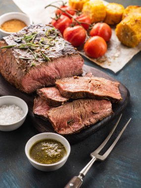 Üzerinde kesme tahtası ızgara sebzeli biftek dilimlenmiş 