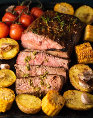 Üzerinde kesme tahtası ızgara sebzeli biftek dilimlenmiş 