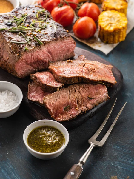 Üzerinde kesme tahtası ızgara sebzeli biftek dilimlenmiş 