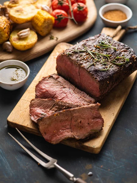 Üzerinde kesme tahtası ızgara sebzeli biftek dilimlenmiş 