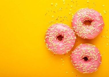 Çeşitli renkli bir arka plan üzerinde renkli lezzetli sırlı çörek.