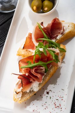 Bruschetta Parma ve keçi peynir, zeytin ve badem ile. Set şarap.