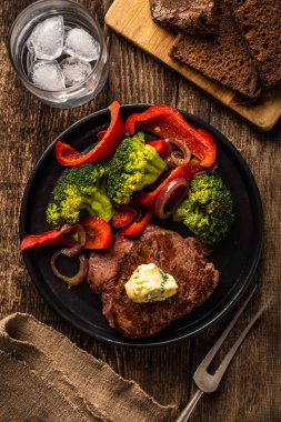 Sarımsak tereyağı ve sebze ızgara sığır eti biftek. Et ızgara dolmalık biber, brokoli ve soğan. Görünümü yukarıdaki.