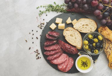 Salam rustik tarzda dilimlenmiş. Salam sosis. Peynir, üzüm ve zeytin ile farklı sosis. Tonda, en iyi görünümü.