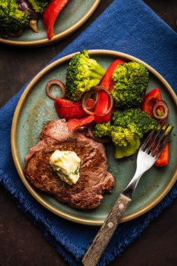 Sarımsak tereyağı ve sebze ızgara sığır eti biftek. Et ızgara dolmalık biber, brokoli ve soğan. Üstten görünüm.