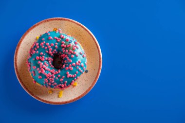 Renkli bir arka plan üzerinde renkli lezzetli sırlı çörek.