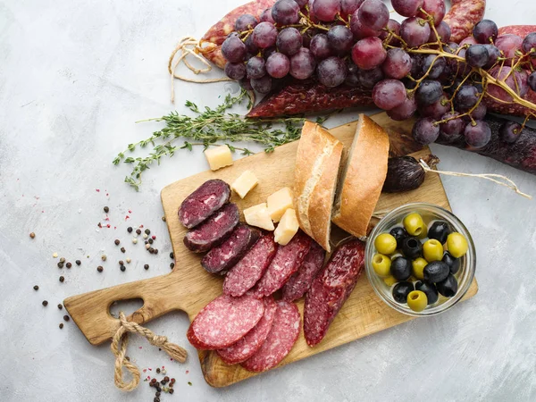別のソーセージとチーズ ブドウとオリーブ 素朴なスタイルのサラミを薄切り トップ ビュー — ストック写真